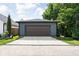 Modern garage with a dark brown door and exterior lighting in a residential setting at 1717 Carrollton Ave, Indianapolis, IN 46202