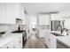 Bright modern kitchen with stainless steel appliances, white cabinets, and beautiful hardwood floors at 1717 Carrollton Ave, Indianapolis, IN 46202