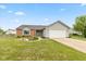 Charming single-story home showcasing a well-manicured lawn, attached garage, and beautiful landscaping at 18005 Gasparilla Ct, Westfield, IN 46062