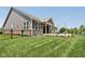Serene backyard featuring a covered patio, lush green grass, and a stylish black fence at 18998 Beverly Shones Ln, Noblesville, IN 46062