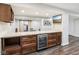Basement bar with a beverage cooler, wood cabinets, and granite counters at 18998 Beverly Shones Ln, Noblesville, IN 46062