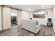 Basement seating area with wood floors, sofa, television screen, and sliding barn door at 18998 Beverly Shones Ln, Noblesville, IN 46062