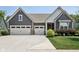 Attractive home showcasing a three-car garage, manicured lawn and charming front yard garden at 18998 Beverly Shones Ln, Noblesville, IN 46062