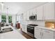 Bright kitchen features stainless steel appliances, white cabinets, countertops, and an adjoining dining area with nature views at 18998 Beverly Shones Ln, Noblesville, IN 46062
