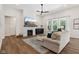Cozy living room with fireplace, modern ceiling fan, and lots of natural light at 18998 Beverly Shones Ln, Noblesville, IN 46062