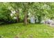 Backyard featuring a shed, lush greenery, and several mature trees at 1938 N Dearborn St, Indianapolis, IN 46218