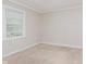 Bright bedroom with a window showing an exterior view, and neutral carpet at 1938 N Dearborn St, Indianapolis, IN 46218