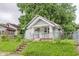 Quaint single-story home with a fenced yard and inviting front steps to a covered porch at 1938 N Dearborn St, Indianapolis, IN 46218