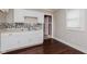 Galley kitchen featuring white cabinetry, a mosaic backsplash, and double bowl sink at 1938 N Dearborn St, Indianapolis, IN 46218