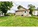 Spacious backyard with lush green grass, new landscaping, and a view of the exterior of this cozy home at 2026 Spruce St, Indianapolis, IN 46203