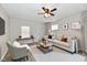 Bright living room showcases a neutral sofa, accent chair, modern rug, and a ceiling fan at 2026 Spruce St, Indianapolis, IN 46203