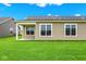 Expansive backyard view showcasing the home's siding, windows, and covered patio with lush green lawn at 2035 Frost Line Ln, Greenfield, IN 46140