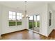 Bright dining room with a modern chandelier, a large window, and sliding glass doors to the patio at 2035 Frost Line Ln, Greenfield, IN 46140