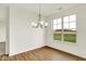 Bright dining room features hardwood floors, a modern chandelier, and large windows with backyard views at 2035 Frost Line Ln, Greenfield, IN 46140