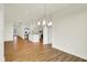 Open dining area featuring hardwood floors, a modern chandelier, and views of the kitchen island at 2035 Frost Line Ln, Greenfield, IN 46140