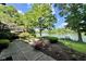 Expansive backyard with a patio, lush landscaping, mature trees, and direct access to the lake at 2213 E Canterbury Ct, Martinsville, IN 46151