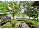 Beautiful backyard featuring a patio, deck, manicured lawn, mature trees, and lake views at 2213 E Canterbury Ct, Martinsville, IN 46151
