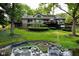 Lakeside backyard featuring a well-maintained lawn, mature trees, a fire pit, and private boat docks at 2213 E Canterbury Ct, Martinsville, IN 46151