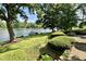 Scenic backyard view with a boat docked on the lake, green lawn, and a charming outdoor patio area at 2213 E Canterbury Ct, Martinsville, IN 46151