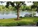 Lush backyard lawn leading to a tranquil lake with a boat dock, and a peaceful seating area at 2213 E Canterbury Ct, Martinsville, IN 46151