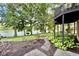 Landscaped backyard with lush greenery, stone pathway, and a view of the serene lake at 2213 E Canterbury Ct, Martinsville, IN 46151