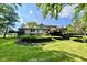 Stunning backyard with a spacious lawn, mature landscaping, direct lake access, and a covered deck at 2213 E Canterbury Ct, Martinsville, IN 46151