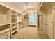 Spacious walk-in closet boasts custom shelving, carpeted floor, and a window for natural light at 2213 E Canterbury Ct, Martinsville, IN 46151