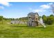 Backyard view of a playset with a slide and swings in a well-manicured lawn with a lake in the background at 2247 Rolling Hill Ct, Columbus, IN 47201