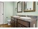 Bathroom with dual sinks, granite countertop, mirrors, and modern fixtures at 2247 Rolling Hill Ct, Columbus, IN 47201