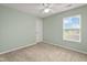 Bright bedroom with neutral carpet, mint-green walls, ceiling fan, and sunny window at 2247 Rolling Hill Ct, Columbus, IN 47201