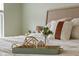 Close-up of a decorated bed with throw pillows, a wooden tray, and other decorative items at 2247 Rolling Hill Ct, Columbus, IN 47201