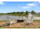 Cozy fire pit area with Adirondack chairs overlooking the pond and fountain at 2247 Rolling Hill Ct, Columbus, IN 47201