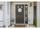 Close-up of front door with 'Welcome' sign, potted plants, and modern exterior lighting at 2247 Rolling Hill Ct, Columbus, IN 47201