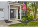 Inviting front porch with a welcoming American flag, landscaped garden, and covered entryway at 2247 Rolling Hill Ct, Columbus, IN 47201