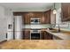 Well-lit kitchen featuring stainless steel appliances, tile backsplash, and dark wood cabinetry at 2247 Rolling Hill Ct, Columbus, IN 47201