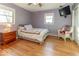 Bedroom with hardwood floors, mounted TV, and natural lighting at 2457 N Centerline Rd, Franklin, IN 46131