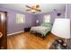This bedroom includes hardwood floors, calming lilac paint and a ceiling fan at 2457 N Centerline Rd, Franklin, IN 46131
