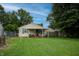 View of a spacious backyard with a covered patio, mature trees, and a well-maintained lawn at 2620 13Th St, Columbus, IN 47201