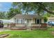 Lovely home with yellow siding, green shutters, and a charming front porch and covered carport at 2620 13Th St, Columbus, IN 47201