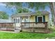 Charming one-story home with yellow siding, green shutters, a covered front porch, and mature trees at 2620 13Th St, Columbus, IN 47201