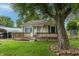 Quaint home with a covered carport, mature landscaping, a front porch, yellow siding, and green shutters at 2620 13Th St, Columbus, IN 47201