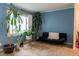 Cozy living room with blue walls, neutral carpet, lots of plants, and comfortable seating at 2620 13Th St, Columbus, IN 47201