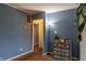 Open-concept living room with blue walls, side table with drawers, and easy access to other rooms at 2620 13Th St, Columbus, IN 47201