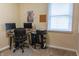 A functional office space featuring a desk, chair, monitors, printer, and natural light at 2620 13Th St, Columbus, IN 47201