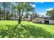 Large backyard with mature trees, lush lawn, and multiple outbuildings at 2907 Jay Dee Ln, Greenwood, IN 46143