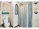 Quaint bathroom with wood-look floors and decorative elements, featuring a bathtub with shower at 2907 Jay Dee Ln, Greenwood, IN 46143