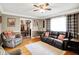 Cozy living room features hardwood floors, a ceiling fan, and comfortable leather seating at 2907 Jay Dee Ln, Greenwood, IN 46143