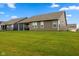 A well-maintained backyard featuring green grass, a covered patio, and a peaceful setting at 3599 Chalmers Dr, Bargersville, IN 46106