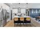 Bright kitchen features a large center island with counter seating, stainless steel appliances, and stylish pendant lighting at 3599 Chalmers Dr, Bargersville, IN 46106