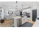Open concept kitchen features a spacious center island with seating, stainless appliances, and hardwood flooring at 3599 Chalmers Dr, Bargersville, IN 46106